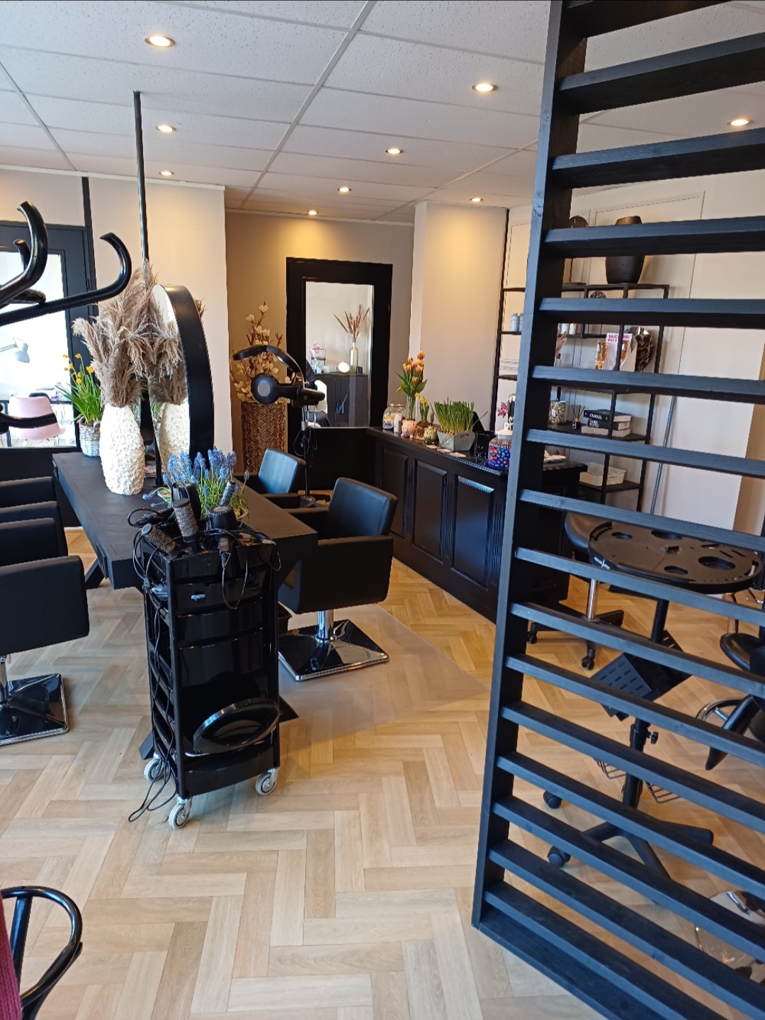 Werkplekken in de salon met de zwarte houten scheidingswand