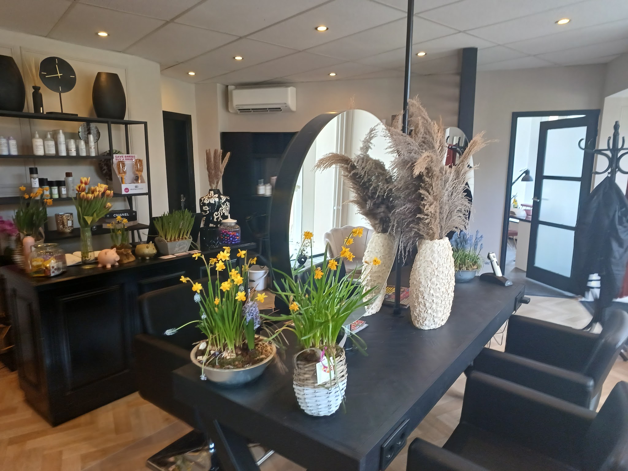 Kaptafel met voorjaarsbloemen en een rek met haarproducten
