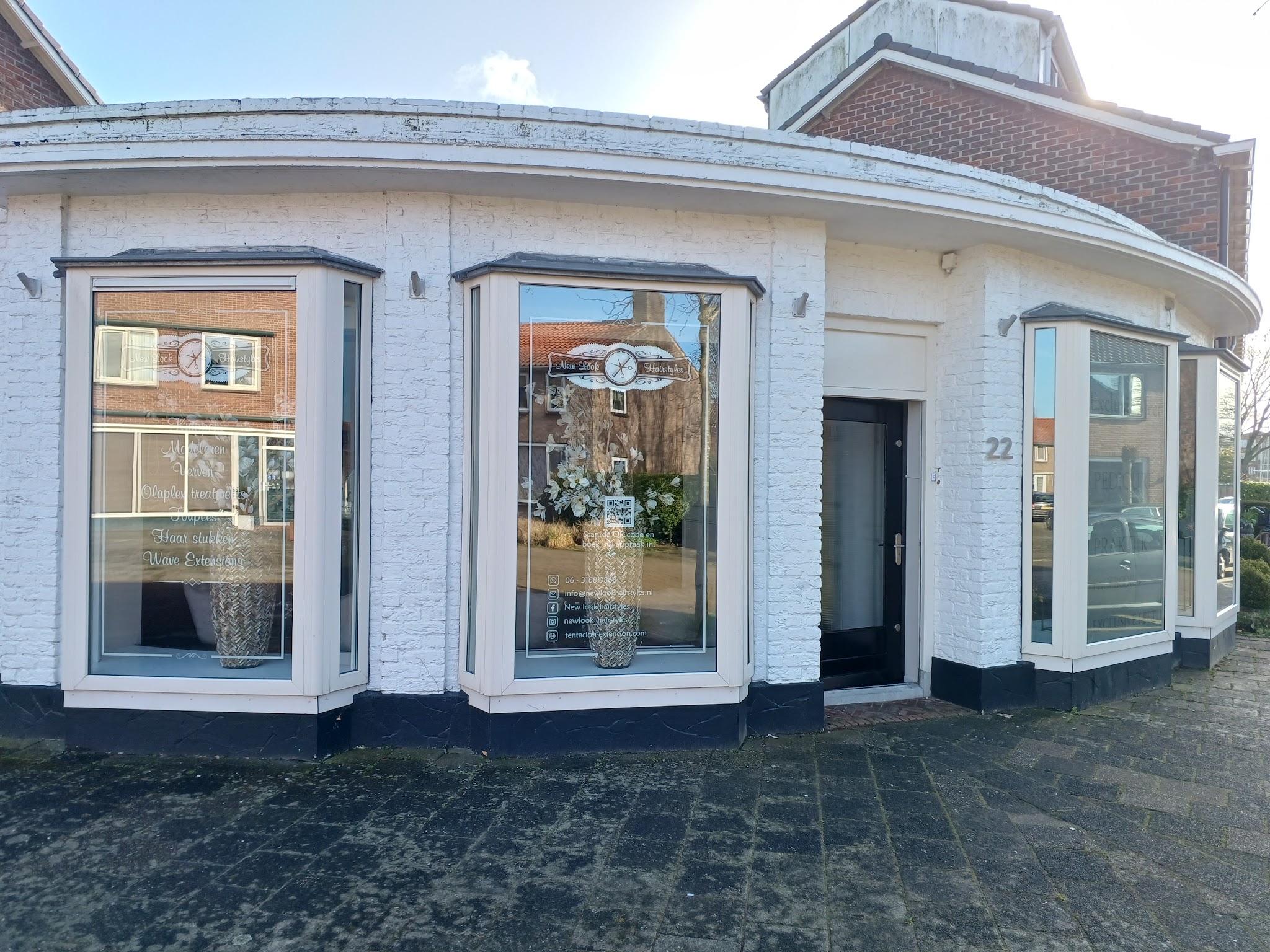 Het witte hoekpand aan de Waterpoortstraat 22 met de naam New Look Hairstyles op het raam